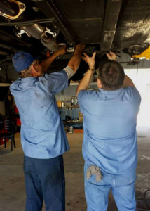Raymond and Rodney Norman working underneath a vehicle in their Jacksonville shop